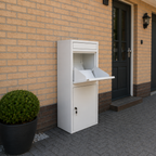 Witte BunnyBox Home met open klep tegen een bakstenen gevel naast de voordeur